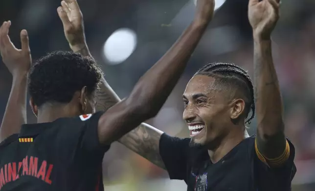 Barcelona's Raphinha celebrates with Lamine Yamal after scoring his side's 5th goal against Villarreal during a Spanish La Liga soccer match at the La Cerámica stadium in Villarreal, Spain, Sunday, Sept. 22, 2024. (AP Photo/Alberto Saiz)