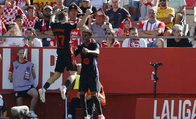 Barcelona's Lamine Yamal, right, celebrates with his teammate Marc Casado after scoring his side's second goal during the Spanish La Liga soccer match between Girona and Barcelona at the Montilivi stadium in Girona, Spain, Sunday, Sept. 15, 2024. (AP Photo/Joan Monfort)