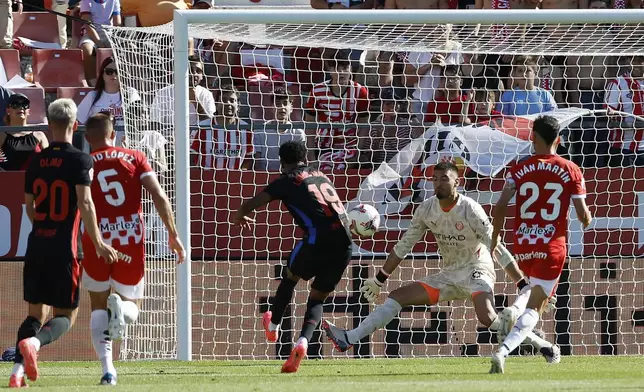 Barcelona's Lamine Yamal, centre, scores his side's opening goal during the Spanish La Liga soccer match between Girona and Barcelona at the Montilivi stadium in Girona, Spain, Sunday, Sept. 15, 2024. (AP Photo/Joan Monfort)