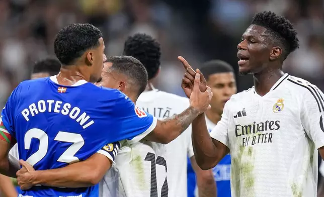 Real Madrid's David Alaba, right, discusses with Alaves' Carlos Benavidez during a Spanish La Liga soccer match between Real Madrid and Alaves at Santiago Bernabeu stadium in Madrid, Spain, Tuesday, Sept. 24, 2024. (AP Photo/Manu Fernandez)