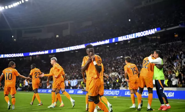 Real Madrid's Vinicius Junior, centre, celebrates after scoring the opening goal with a penalty kick during a Spanish La Liga soccer match between Real Sociedad and Real Madrid at the Reale Arena in San Sebastian, Spain, Saturday, Sept. 14, 2024. (AP Photo/Miguel Oses)