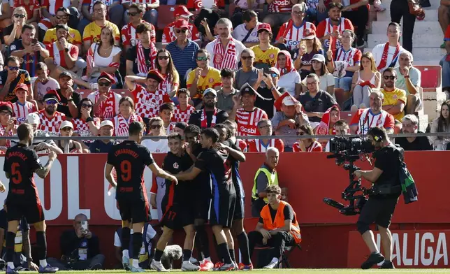 Barcelona's Lamine Yamal, centre, celebrates with his teammates after scoring his side's second goal during the Spanish La Liga soccer match between Girona and Barcelona at the Montilivi stadium in Girona, Spain, Sunday, Sept. 15, 2024. (AP Photo/Joan Monfort)