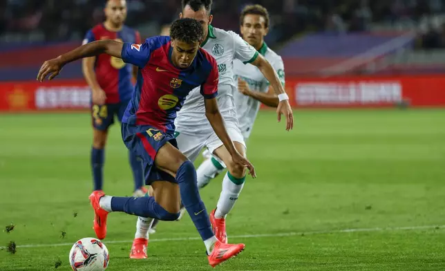 Barcelona's Lamine Yamal, front, duels for the ball with Getafe's Alex Sola during a Spanish La Liga soccer match between Barcelona and Getafe at the Olympic stadium in Barcelona, Spain, Wednesday, Sept. 25, 2024. (AP Photo/Joan Monfort)