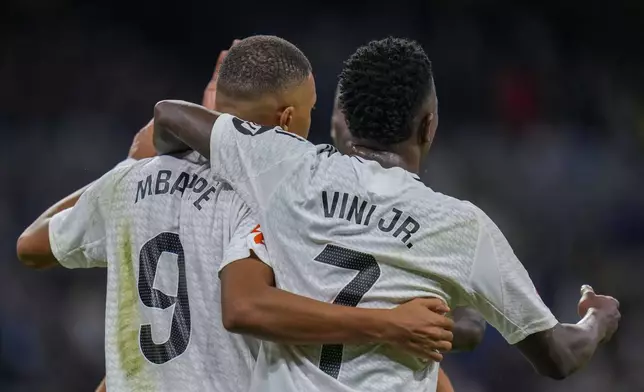 Real Madrid's Kylian Mbappe, left, celebrates with teammates after scoring his side's second goal during a Spanish La Liga soccer match between Real Madrid and Alaves at Santiago Bernabeu stadium in Madrid, Spain, Tuesday, Sept. 24, 2024. (AP Photo/Manu Fernandez)