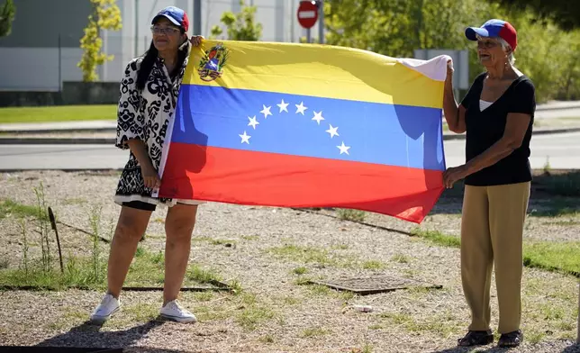 Supporters of Edmundo González wait for his arrival outside the Torrejón Air Base in Madrid, Spain, Sunday, Sept. 8, 2024. Former Venezuelan opposition presidential candidate Edmundo González has fled into exile after being granted asylum in Spain, delivering a major blow to millions who placed their hopes in his upstart campaign to end two decades of single-party rule. (AP Photo/Andrea Comas)