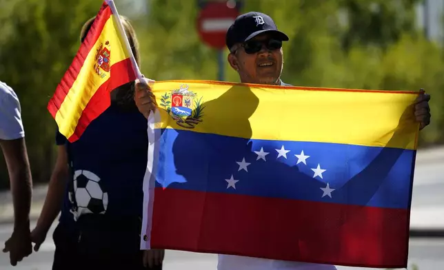 Supporters of Edmundo González gather outside the Torrejón Air Base in Madrid, Spain, Sunday, Sept. 8, 2024. Former Venezuelan opposition presidential candidate Edmundo González has fled into exile after being granted asylum in Spain, delivering a major blow to millions who placed their hopes in his upstart campaign to end two decades of single-party rule. (AP Photo/Andrea Comas)