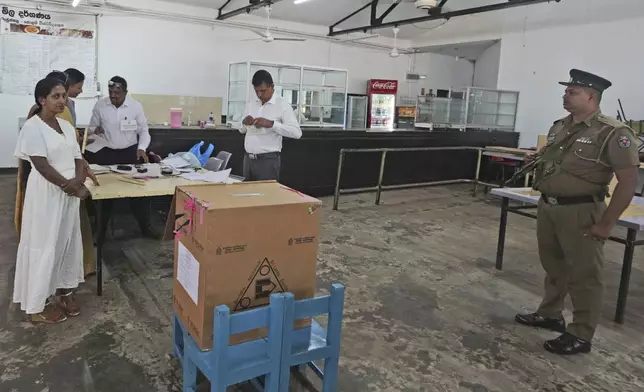 A police officer stands guard as polling officers set up their booth in Colombo, Sri Lanka, Saturday, Sept. 21, 2024. (AP Photo/Rajesh Kumar Singh)