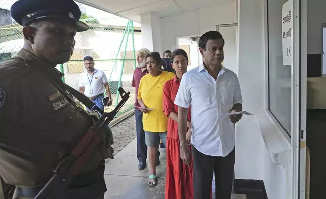 People wait in a queue to casts their votes at a polling station in Colombo, Sri Lanka, Saturday, Sept. 21, 2024. (AP Photo/Rajesh Kumar Singh)