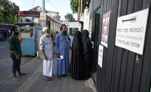 People stand in a queue to cast their votes in Colombo, Sri Lanka, Saturday, Sept. 21, 2024. (AP Photo/Eranga Jayawardane)