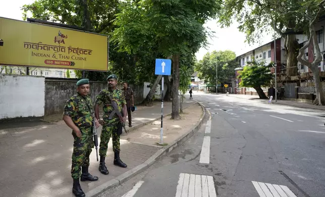 Police commandos stand guard, as a countrywide curfew was imposed then, outside a ballot counting center during the presidential election in Colombo, Sri Lanka, Sunday, Sept. 22, 2024. (AP Photo/Rajesh Kumar Singh)