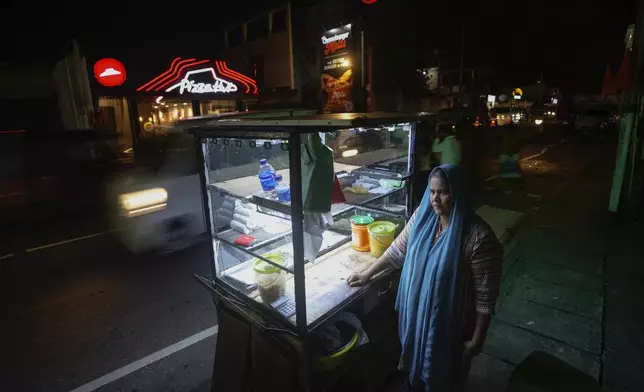 Fathima Shiyama, 48, waits for customers next to her food cart in Colombo, Sri Lanka, Tuesday, Sept. 3, 2024. (AP Photo/Eranga Jayawardena)