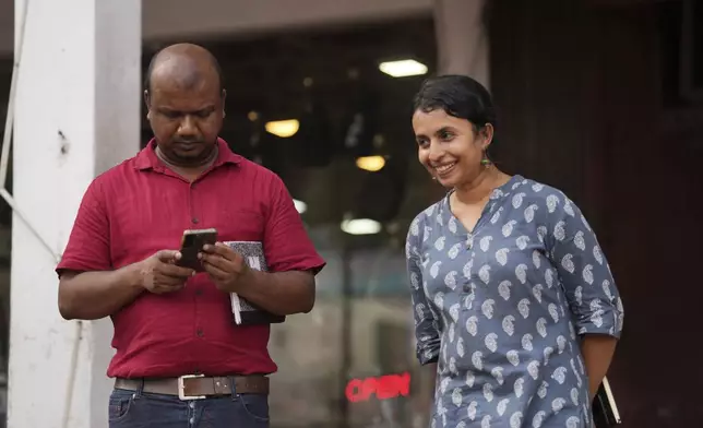 Swasthika Arulingam, right, 37, a human rights lawyer and a minority Tamil, who offered legal aid to protesters during the uprising, talks to Nuwan Bopage, a presidential candidate from People's Struggle Alliance during an election campaign in Colombo, Sri Lanka, Monday, Sept. 16, 2024. (AP Photo/Rajesh Kumar Singh)