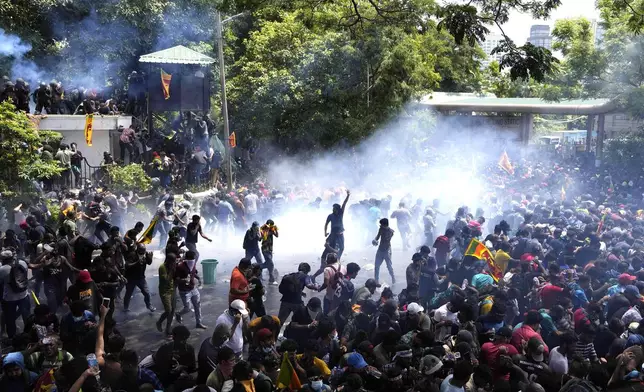 FILE - Police fire tear gas as protesters stormed the compound of Prime Minister Ranil Wickremesinghe demanding he resign after President Gotabaya Rajapaksa fled the country amid an economic crisis in Colombo, Sri Lanka, on July 13, 2022. (AP Photo/Eranga Jayawardena, File)