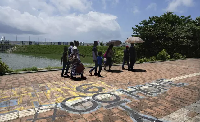 People walk past a graffiti near the 2022 protest site that reads "Go Home Gota," a slogan under which Sri Lankans where mobilized during the public uprising that led to the ousting of the then president Gotabaya Rajapaksa, in Colombo, Sri Lanka, Monday, Sept. 16, 2024. (AP Photo/Rajesh Kumar Singh)