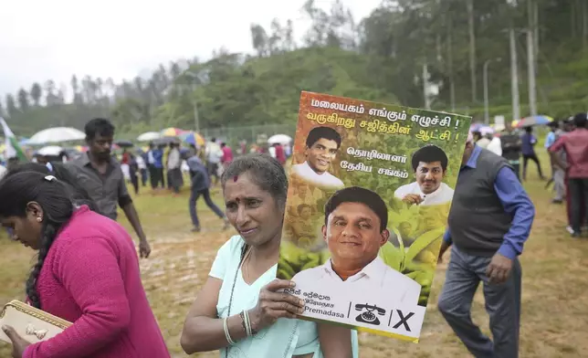 A tea plantation worker carries an election poster showing a portrait of the opposition leader and presidential candidate Sajith Premadasa, during an election rally in Thalawakele, Sri Lanka, Sunday, Sept. 8, 2024. (AP Photo/Eranga Jayawardena)