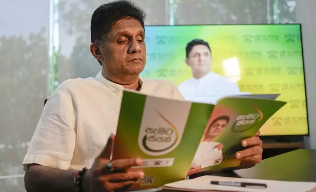 Opposition leader and the presidential candidate of United People's Power Sajith Premadasa looks at his election manifesto after an interview with The Associated Press in Colombo, Sri Lanka, Thursday, Sept. 12, 2024. (AP Photo/Eranga Jayawardena)