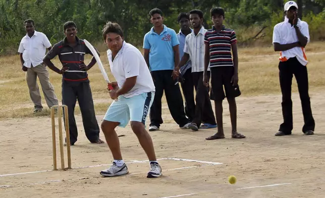 FILE- Namal Rajapaksa, center, Sri Lankan lawmaker and son of President Mahinda Rajapaksa, plays cricket with ethnic Tamil youth in Killinochchi, Sri Lanka, Thursday July 21, 2011. (AP Photo/ Eranga Jayawardena, File)