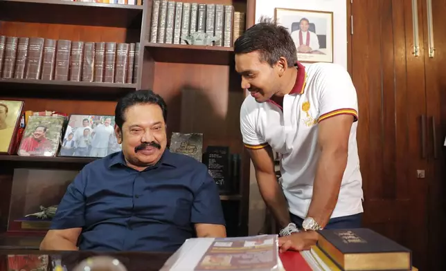 FILE - Sri Lankan Prime Minister Mahinda Rajapaksa speaks with his lawmaker son Namal following his election victory in the general election at his residence in Tangalle, Sri Lanka, Friday, Aug. 7, 2020.(AP Photo/Eranga Jayawardena, File)