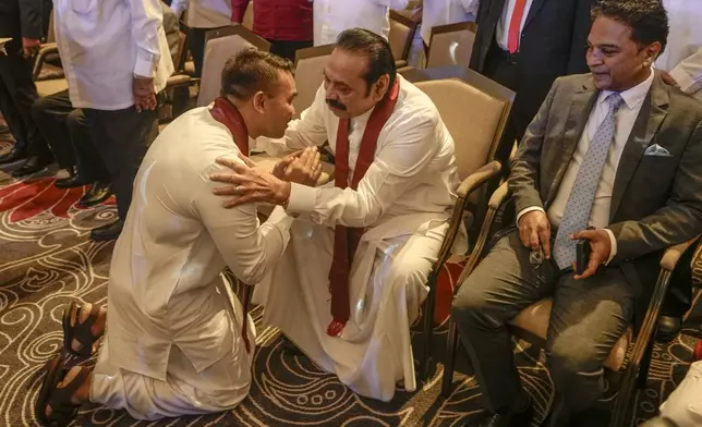 FILE - Presidential candidate Namal Rajapaksa bows down before his father and former president Mahinda Rajapaksa during the launching of his election manifesto in Colombo, Sri Lanka, Monday, Sept. 2, 2024. (AP Photo/Eranga Jayawardena, File)