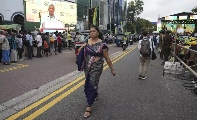 A woman walks on a street across which a large billboard showing a portrait of Sajith Premadasa, the presidential candidate and opposition leader of the Samagi Jana Balawgaya or United People's Power party, is displayed, in Colombo, Sri Lanka, Wednesday, Sept. 18, 2024. (AP Photo/Rajesh Kumar Singh)