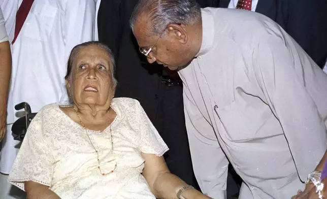 FILE - Sirimavo Bandaranaike, left, thrice Sri Lanka's prime minister, talks with her successor Ratnasiri Wickramanayake after he was sworn in, in Colombo, Sri Lanka, Aug. 10, 2000. (AP Photo, File)