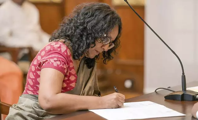 National People's power lawmaker Harini Amarasuriya, 54, signs after taking oath for the post of Sri Lanka's Prime Minister in Colombo, Sri Lanka, Monday, Sept. 23, 2024. (Sri Lanka Government Information Department via AP)