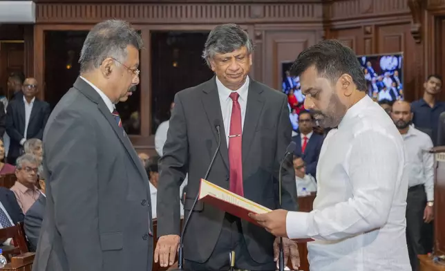 Marxist leader Anura Kumara Dissanayake, right, is sworn in as Sri Lanka's tenth president by Chief Justice Jayantha Jayasuriya, left at the Sri Lankan President's Office in Colombo, Sri Lanka, Monday, Sept.23, 2024. President's secretary Saman Ekanayake is in center. (Sri Lankan President's Office via AP)