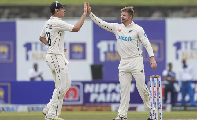 New Zealand's Glenn Phillips, right, celebrates the wicket of Sri Lanka's Angelo Mathews with captain Tim Southee during the day two of the first test cricket match between Sri Lanka and New Zealand in Galle, Sri Lanka, Friday, Sept. 27, 2024. (AP Photo/Eranga Jayawardena)