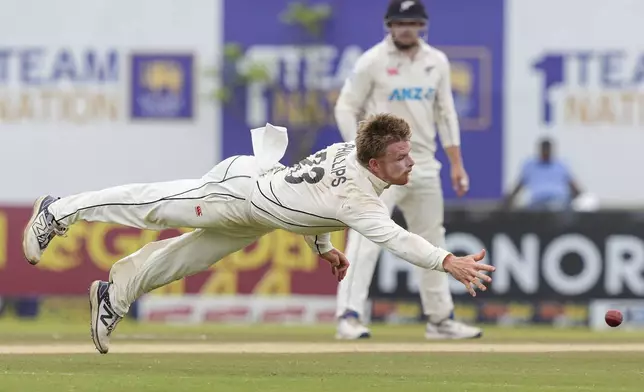 New Zealand's Glenn Phillips dives to stop the ball during the day two of the first test cricket match between Sri Lanka and New Zealand in Galle, Sri Lanka, Friday, Sept. 27, 2024. (AP Photo/Eranga Jayawardena)