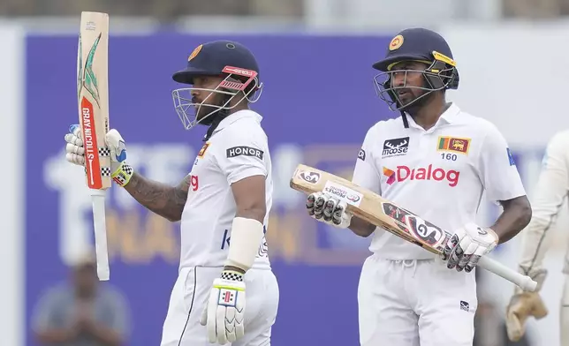 Sri Lanka's Kusal Mendis celebrates his fifty runs as Kamindu Mendis watches during the day two of the first test cricket match between Sri Lanka and New Zealand in Galle, Sri Lanka, Friday, Sept. 27, 2024. (AP Photo/Eranga Jayawardena)
