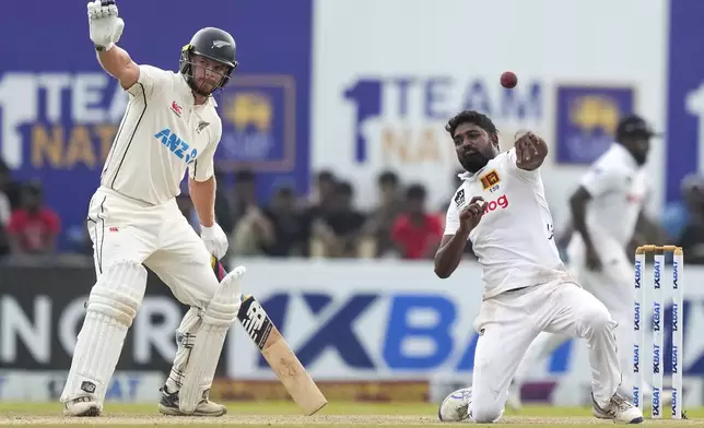 Sri Lanka's Prabath Jayasuriya throws a ball as New Zealand's Glenn Phillips watches during the day three of the second test cricket match between Sri Lanka and New Zealand in Galle , Sri Lanka, Saturday, Sept. 28, 2024. (AP Photo/Eranga Jayawardena)
