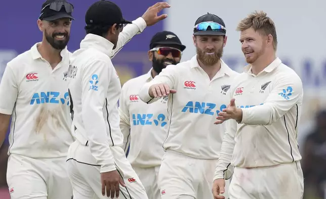 New Zealand's Glenn Phillips celebrates the wicket of Sri Lanka's captain Dhananjaya de Silva with teammates during the day two of the first test cricket match between Sri Lanka and New Zealand in Galle, Sri Lanka, Friday, Sept. 27, 2024. (AP Photo/Eranga Jayawardena)