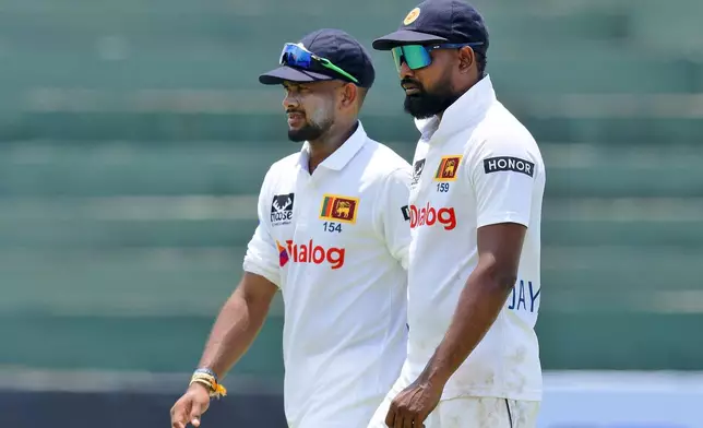 Sri Lanka's Ramesh Mendis, left, and teammate Prabath Jayasuriya leave the ground at the end of the New Zealand innings on the third day of the first cricket test match between New Zealand and Sri Lanka in Galle, Sri Lanka, Friday, Sept. 20, 2024. (AP Photo/Viraj Kothalawala)