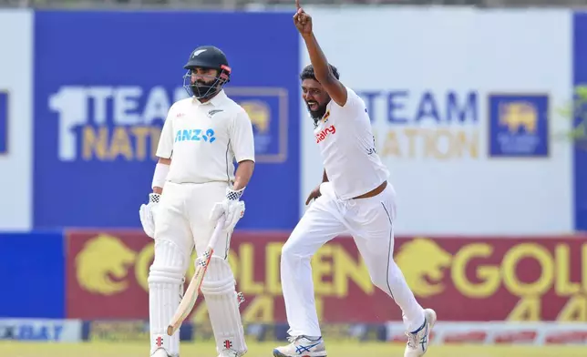 Sri Lanka's Prabath Jayasuriya, right, celebrates the wicket of New Zealand's Rachin Ravindra on the fifth and final day of the first cricket test match between New Zealand and Sri Lanka in Galle, Sri Lanka, Monday, Sept. 23, 2024. (AP Photo/Viraj Kothalawala)