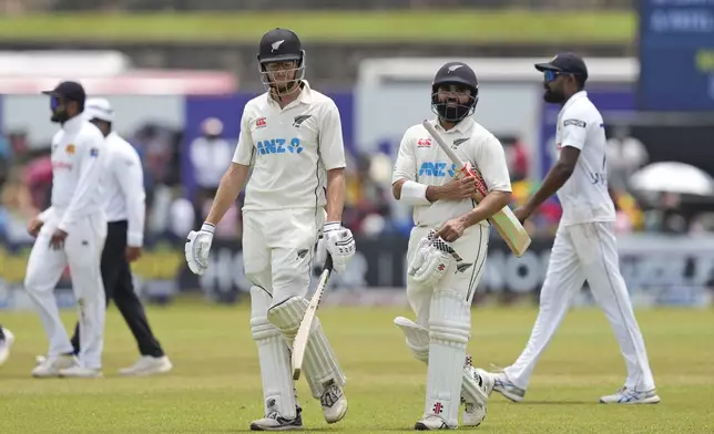 New Zealand's Mitchell Santner and Ajaz Patel return to pavilion in the lunch break during the day four of the second test cricket match between Sri Lanka and New Zealand in Galle, Sri Lanka, Sunday, Sept. 29, 2024. (AP Photo/Eranga Jayawardena)