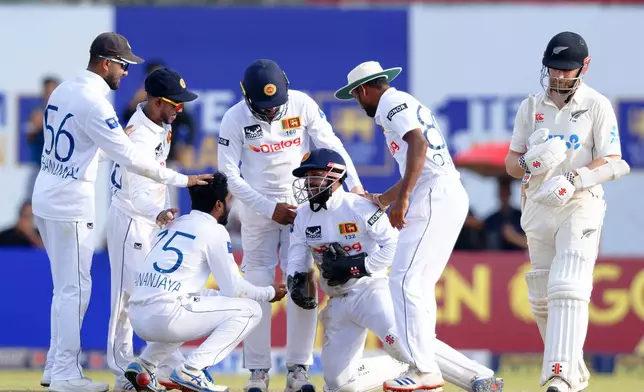 Sri Lanka's wicketkeeper Kusal Mendis, third right, is congratulated by teammates for taking the catch to get New Zealand's Kane Williamson, right, out on the second day of the first cricket test match between New Zealand and Sri Lanka in Galle, Sri Lanka, Thursday, Sept. 19, 2024. (AP Photo/Viraj Kothalawala)