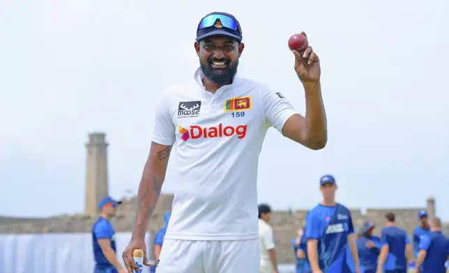 Sri Lanka's Prabath Jayasuriya displays the ball to celebrate his five-wicket haul in the second innings after Sri Lanka won the first cricket test match against New Zealand in Galle, Sri Lanka, Monday, Sept. 23, 2024. (AP Photo/Viraj Kothalawala)