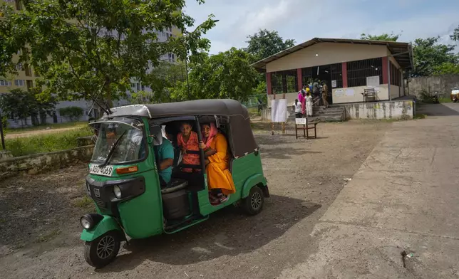 A Sri Lankan family sit in a rickshaw as they leave a polling station after casting their votes in Colombo, Sri Lanka, Saturday, Sept. 21, 2024. (AP Photo/Eranga Jayawardena)