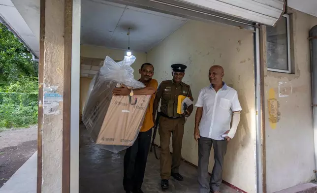 Polling officials carry a sealed ballot box as they return it to a counting center at the end of voting during presidential election in Colombo, Sri Lanka, Saturday, Sept. 21, 2024. (AP Photo/Rajesh Kumar Singh)