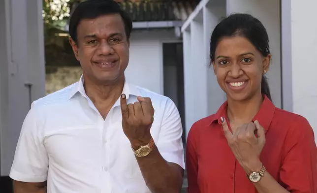 Sri Lankan show their baby fingers marked with an indelible ink after casting their vote at a polling center for presidential election in Colombo, Sri Lanka, Saturday, Sept. 21, 2024. (AP Photo/Rajesh Kumar Singh)