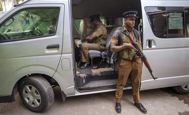 A police officer sits next to a sealed ballot box as polling officials prepare to return it to a counting center at the end of voting during presidential election in Colombo, Sri Lanka, Saturday, Sept. 21, 2024. (AP Photo/Rajesh Kumar Singh)