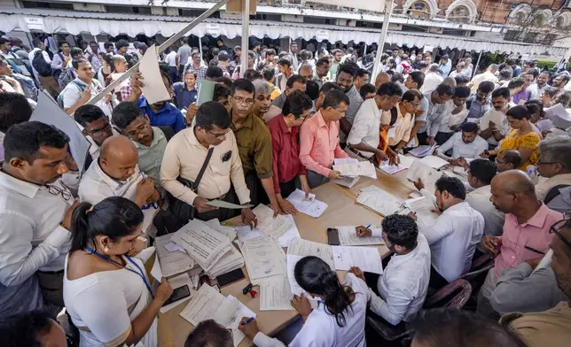 Polling officers take their duty slips for their respective polling booths from a distribution center for the upcoming presidential election in Colombo, Sri Lanka, Friday, Sept. 20, 2024.. (AP Photo/Rajesh Kumar Singh)