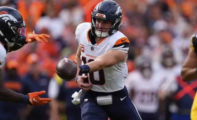 Denver Broncos quarterback Bo Nix (10) hands off the ball during the second half of an NFL football game against the Pittsburgh Steelers, Sunday, Sept. 15, 2024, in Denver. (AP Photo/David Zalubowski)