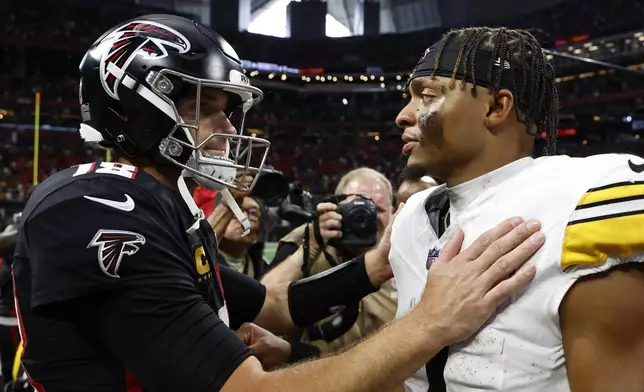 Atlanta Falcons quarterback Kirk Cousins, left, and Pittsburgh Steelers quarterback Justin Fields meet after the Steelers won the NFL football game Sunday, Sept. 8, 2024, in Atlanta. (AP Photo/Butch Dill)