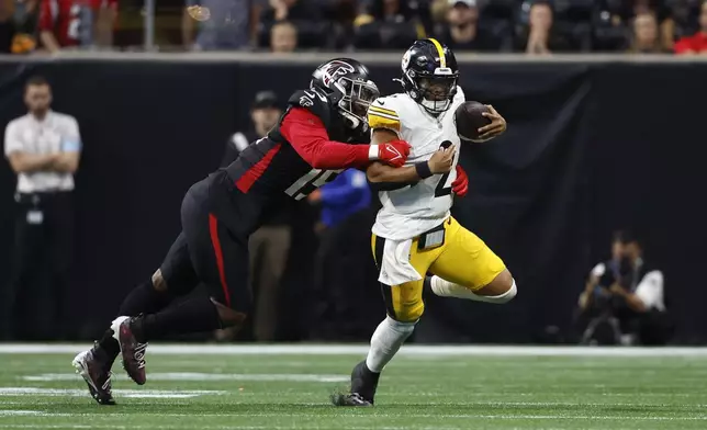 Pittsburgh Steelers quarterback Justin Fields (2) is stopped by Atlanta Falcons defensive tackle Kentavius Street (75) during the second half of an NFL football game Sunday, Sept. 8, 2024, in Atlanta. (AP Photo/Butch Dill)