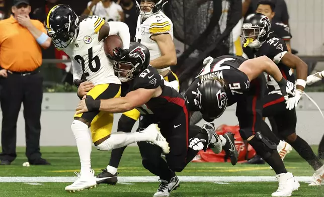 Pittsburgh Steelers cornerback Donte Jackson (26) is tackled by Atlanta Falcons center Drew Dalman (67) after an interception during the second half of an NFL football game Sunday, Sept. 8, 2024, in Atlanta. (AP Photo/Butch Dill)