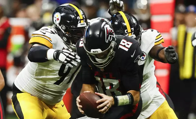 Atlanta Falcons quarterback Kirk Cousins (18) is sacked by Pittsburgh Steelers defensive tackle Cameron Heyward (97) and teammate defensive tackle Montravius Adams (57) during the second half of an NFL football game Sunday, Sept. 8, 2024, in Atlanta. (AP Photo/Butch Dill)