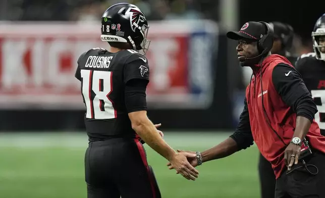 Atlanta Falcons head coach Raheem Morris greets Falcons quarterback Kirk Cousins during the first half of an NFL football game against the Pittsburgh Steelers on Sunday, Sept. 8, 2024, in Atlanta. (AP Photo/John Bazemore)