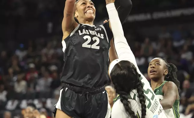 Las Vegas Aces center A'ja Wilson (22) goes up to shoot around Seattle Storm guards Victoria Vivians (35) and Jewell Loyd (24) during a first-round WNBA basketball playoff game Sunday, Sept. 22, 2024, in Las Vegas. (AP Photo/Ronda Churchill)