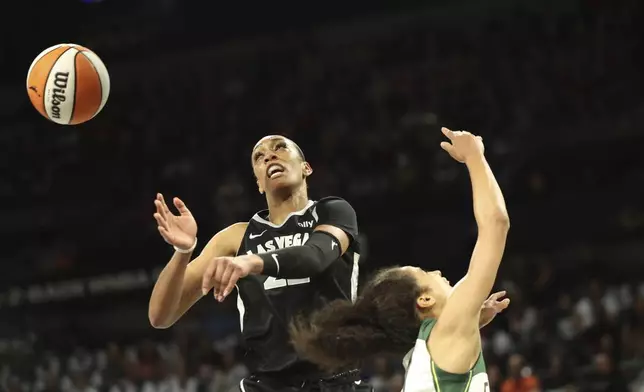 Las Vegas Aces center A'ja Wilson (22) goes to block Seattle Storm guard Skylar Diggins-Smith (4) during a first-round WNBA basketball playoff game Sunday, Sept. 22, 2024, in Las Vegas. (AP Photo/Ronda Churchill)